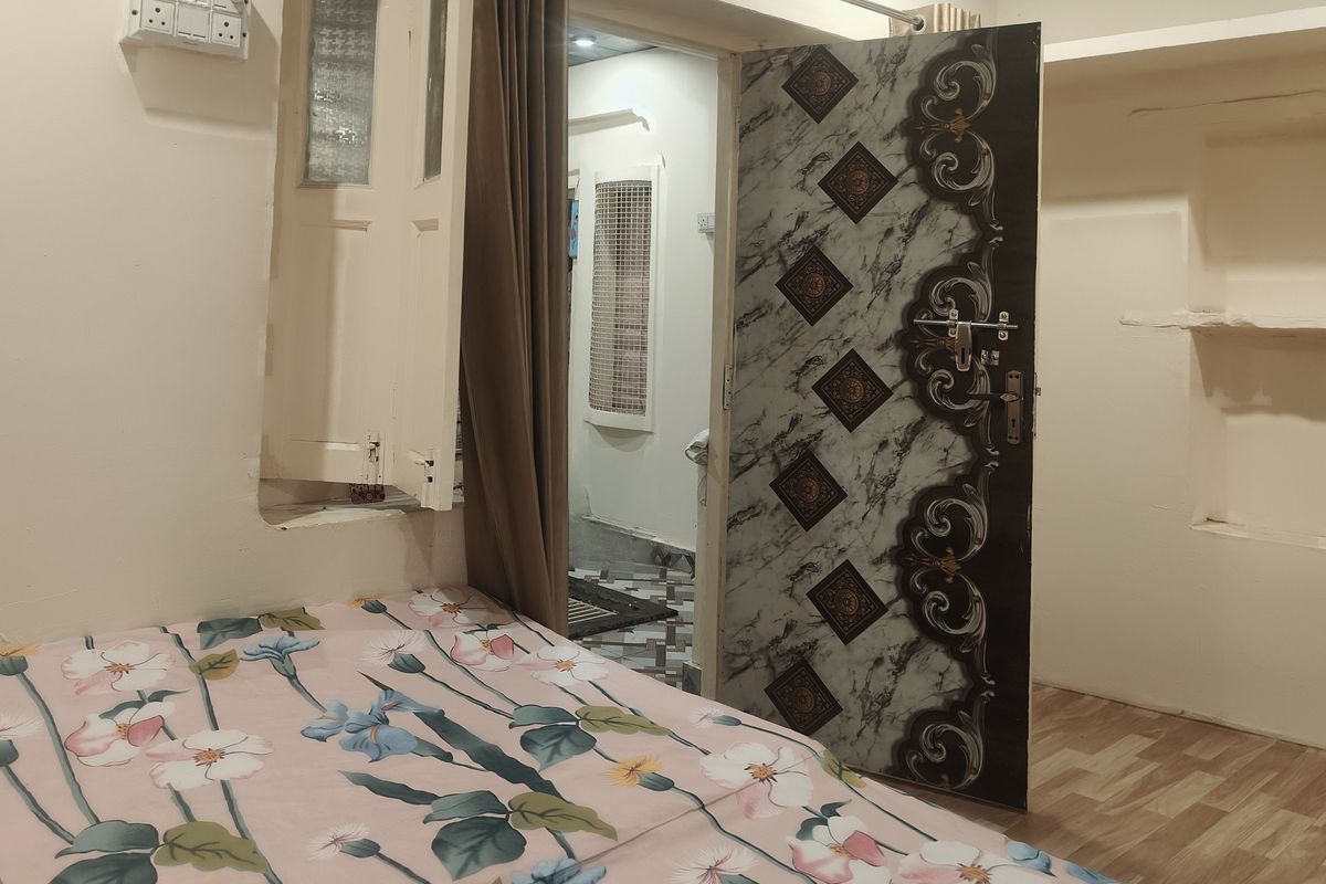 A double room with a floral bedspread and an ornate door